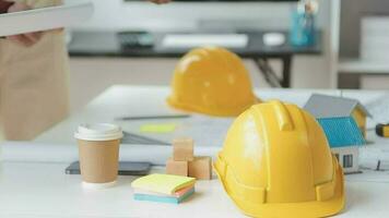 Business objects of team engineers office with construction engineer architect and worker looking building model video