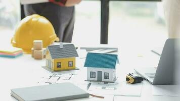 företag objekt av team ingenjörer kontor med konstruktion ingenjör arkitekt och arbetstagare ser byggnad modell video