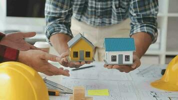 företag objekt av team ingenjörer kontor med konstruktion ingenjör arkitekt och arbetstagare ser byggnad modell video