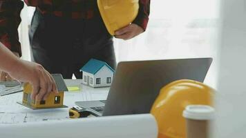 negocio objetos de equipo ingenieros oficina con construcción ingeniero arquitecto y trabajador mirando edificio modelo video