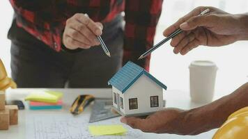 företag objekt av team ingenjörer kontor med konstruktion ingenjör arkitekt och arbetstagare ser byggnad modell video