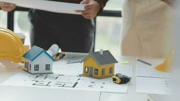 Business objects of team engineers office with construction engineer architect and worker looking building model video