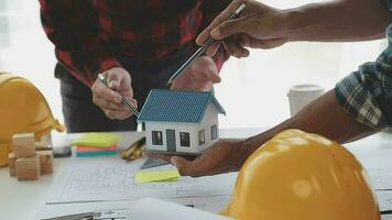 företag objekt av team ingenjörer kontor med konstruktion ingenjör arkitekt och arbetstagare ser byggnad modell video