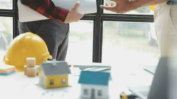 Business objects of team engineers office with construction engineer architect and worker looking building model video