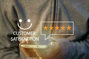 close up Man hand using smartphone with popup five star icon for feedback review satisfaction service, Customer service experience and business satisfaction survey. photo