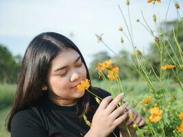 Portrait of gardener young woman asian chubby cute beautiful one person looking hand holding caring for plants leaves garden park beauty flowers evening sunlight fresh smiling happy relax summer day photo