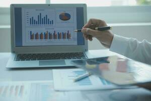 Close up businessman hand using calculator and working with laptop calculate about finance accounting at coffeeshop outdor.finance accounting concept photo
