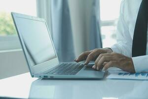 Close up businessman hand using calculator and working with laptop calculate about finance accounting at coffeeshop outdor.finance accounting concept photo