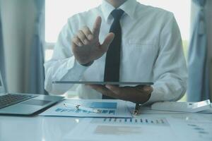 Close up businessman hand using calculator and working with laptop calculate about finance accounting at coffeeshop outdor.finance accounting concept photo