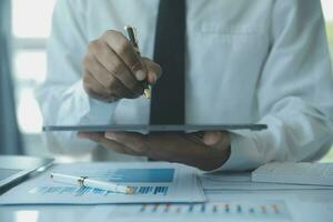 Close up businessman hand using calculator and working with laptop calculate about finance accounting at coffeeshop outdor.finance accounting concept photo