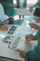 Mature doctors and young nurses stacking hands together at hospital. Close up hands of medical team stacking hands. Group of successful medical doctors and nurses stack of hands. photo