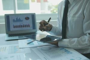 Close up businessman hand using calculator and working with laptop calculate about finance accounting at coffeeshop outdor.finance accounting concept photo