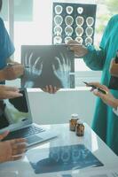 Mature doctors and young nurses stacking hands together at hospital. Close up hands of medical team stacking hands. Group of successful medical doctors and nurses stack of hands. photo