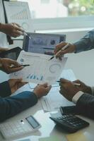 Financial analysts analyze business financial reports on a digital tablet planning investment project during a discussion at a meeting of corporate showing the results of their successful teamwork. photo