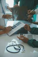 Mature doctors and young nurses stacking hands together at hospital. Close up hands of medical team stacking hands. Group of successful medical doctors and nurses stack of hands. photo