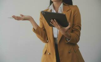 Asian Business woman using calculator and laptop for doing math finance on an office desk, tax, report, accounting, statistics, and analytical research concept photo