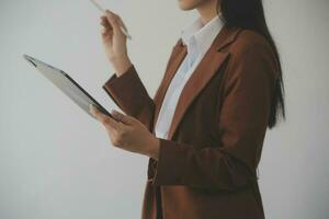 Asian Business woman using calculator and laptop for doing math finance on an office desk, tax, report, accounting, statistics, and analytical research concept photo