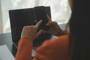 Asian Business woman using calculator and laptop for doing math finance on an office desk, tax, report, accounting, statistics, and analytical research concept photo