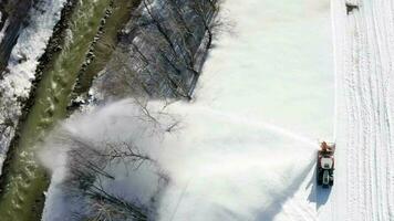 Snow thrower is cleaning the football field from snow. Bird's eye view video