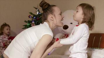 Young mother plays with her children in the bed before bringing them to sleep video