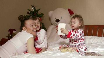 Young mother shows wooden box with old photos to her small children video