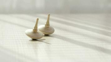 Two small spinning top moving on a table with negative space. video