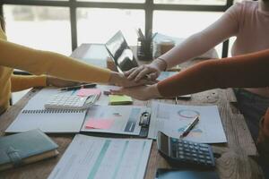 Close up top view of young business people putting their hands together. Stack of hands. Unity and teamwork concept. photo