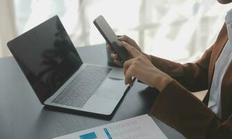 Asian Business woman using calculator and laptop for doing math finance on an office desk, tax, report, accounting, statistics, and analytical research concept photo