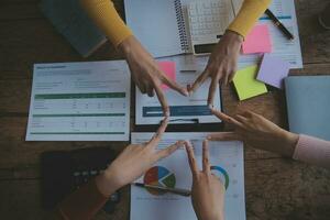 Close up top view of young business people putting their hands together. Stack of hands. Unity and teamwork concept. photo