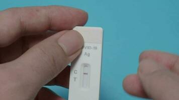 POV of Man hands using Rapid antigen test kit or ATK and blue background. video