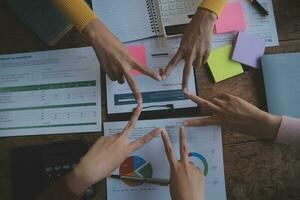 Close up top view of young business people putting their hands together. Stack of hands. Unity and teamwork concept. photo