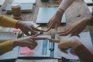 Close up top view of young business people putting their hands together. Stack of hands. Unity and teamwork concept. photo