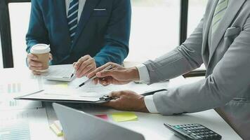 concentração total no trabalho. grupo de jovens empresários trabalhando e se comunicando enquanto estão sentados na mesa do escritório junto com colegas sentados em segundo plano video