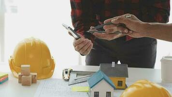 negocio objetos de equipo ingenieros oficina con construcción ingeniero arquitecto y trabajador mirando edificio modelo video