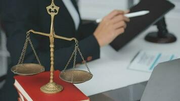 Justice and law concept.Male judge in a courtroom with the gavel, working with, computer and docking keyboard, eyeglasses, on table in morning light video
