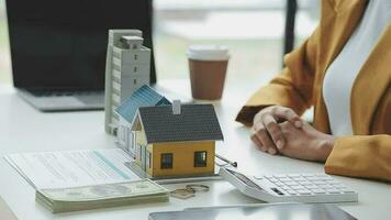 Real estate broker agent presenting and consult to customer to decision making sign insurance form agreement, buy and sell home model, concerning mortgage loan offer for and house insurance video