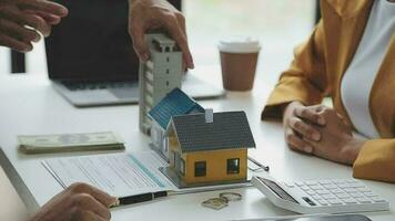 Real estate broker agent presenting and consult to customer to decision making sign insurance form agreement, buy and sell home model, concerning mortgage loan offer for and house insurance video