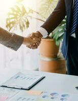 Real estate broker agent and customer shaking hands after signing contract documents for realty purchase, Bank employees congratulate, Concept mortgage loan approval. photo