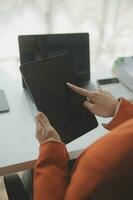 Close up Business woman using calculator and laptop for do math finance on wooden desk, tax, accounting, statistics and analytical research concept photo