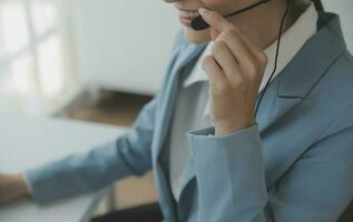 Beautiful female call center operator working on computer in office photo