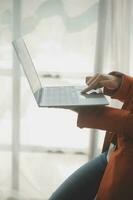Close up Business woman using calculator and laptop for do math finance on wooden desk, tax, accounting, statistics and analytical research concept photo