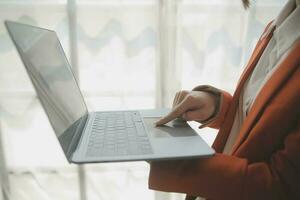 el retrato de una joven mujer asiática independiente está trabajando en su trabajo en una tableta de computadora en una oficina moderna. hacer un informe de análisis contable datos de inversión inmobiliaria, concepto de sistemas financieros y fiscales. foto