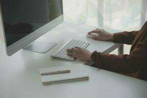 el retrato de una joven mujer asiática independiente está trabajando en su trabajo en una tableta de computadora en una oficina moderna. hacer un informe de análisis contable datos de inversión inmobiliaria, concepto de sistemas financieros y fiscales. foto