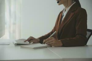 Beautiful female call center operator working on computer in office photo