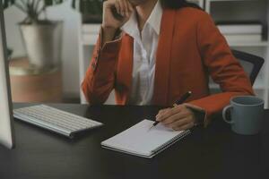 el retrato de una joven mujer asiática independiente está trabajando en su trabajo en una tableta de computadora en una oficina moderna. hacer un informe de análisis contable datos de inversión inmobiliaria, concepto de sistemas financieros y fiscales. foto