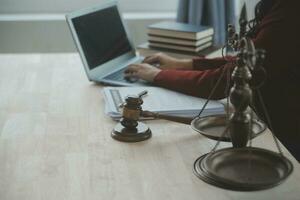 Justice and law concept.Male judge in a courtroom with the gavel, working with, computer and docking keyboard, eyeglasses, on table in morning light photo