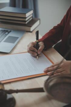 Justice and law concept.Male judge in a courtroom with the gavel, working with, computer and docking keyboard, eyeglasses, on table in morning light photo