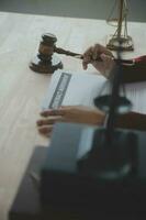 Justice and law concept.Male judge in a courtroom with the gavel, working with, computer and docking keyboard, eyeglasses, on table in morning light photo