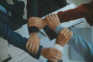 Large business team showing unity with their hands together photo