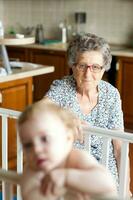 A senior woman and a granddaughter of one year old in its bed photo